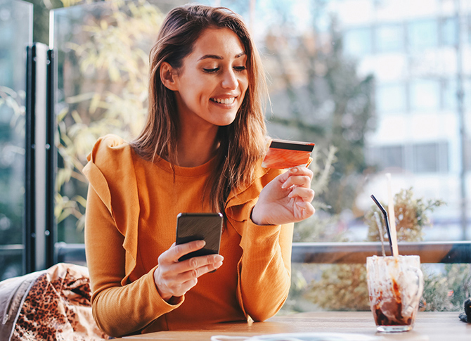 Person using their phone and credit card.