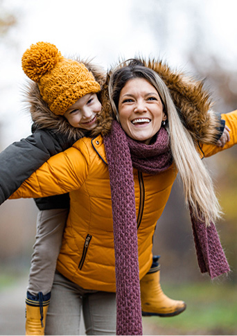 Parent and child playing outdoors in the cold.